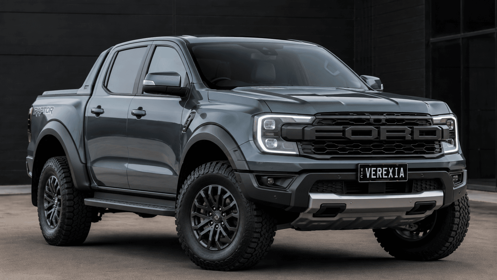 Grey Ford Ranger Raptor dual-cab ute with a Verexia number plate, against a dark wall